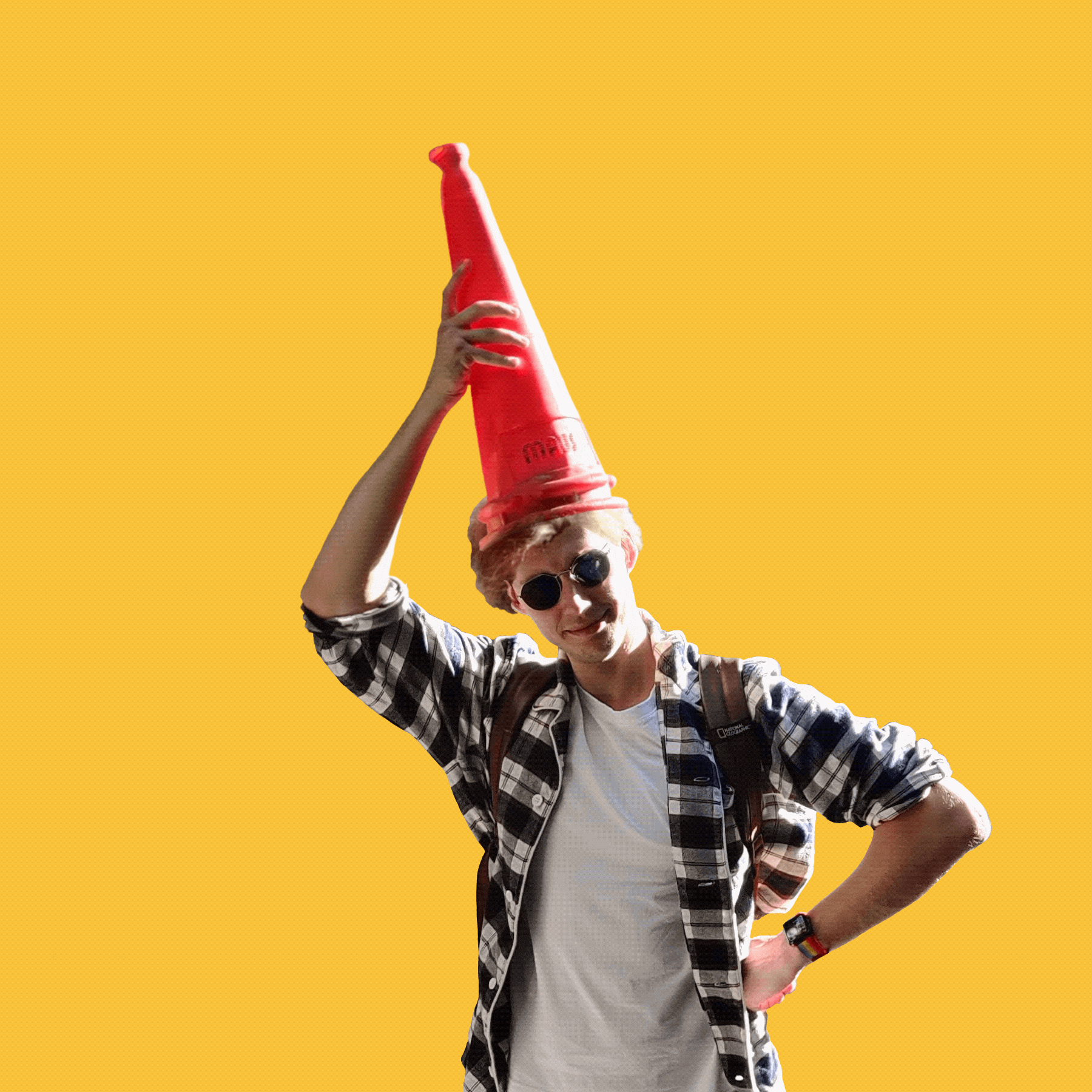 Alternate somewhat professional GIF image of Daniel Bilyk, where he takes a road cone off his head and puts it back on again on a warm yellow background.